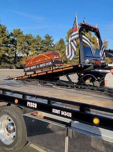 Flatbed tow truck flying a thin yellow line flag