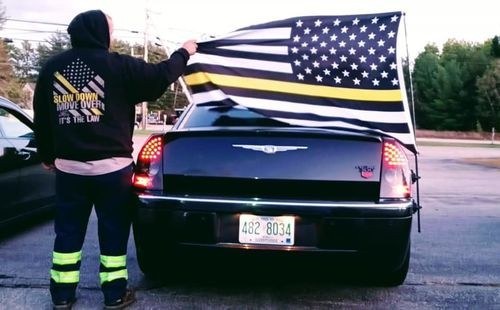 Customer in a Tow Lives Matter hoodie flying a thin yellow line flag from his car