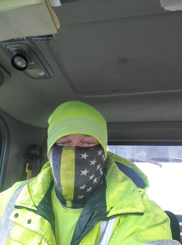 Tow operator in a hi-vis jacket wearing a thin yellow line neck gaiter